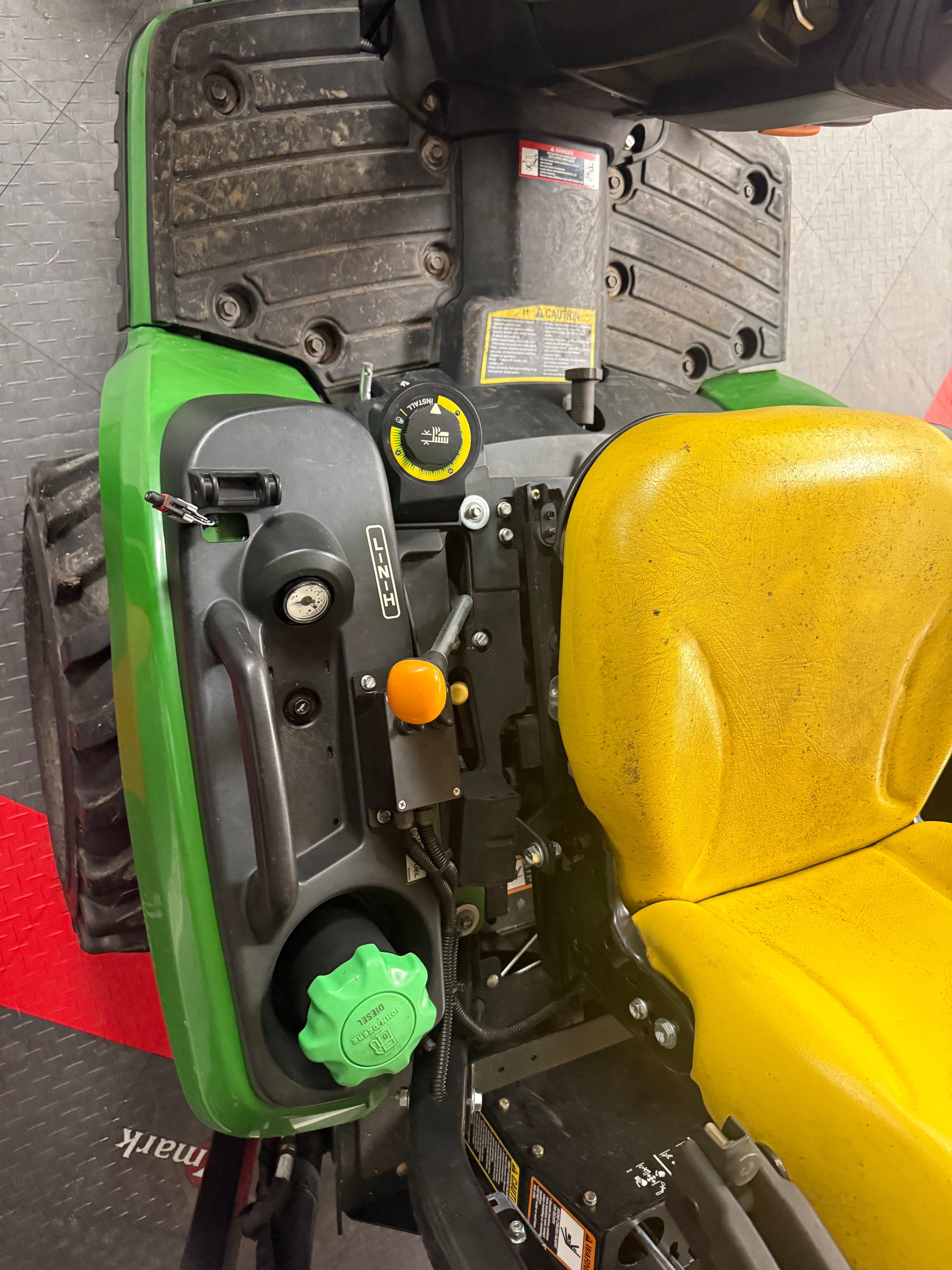 Close-up of a lawn mower with visible brand name on a gray floor.