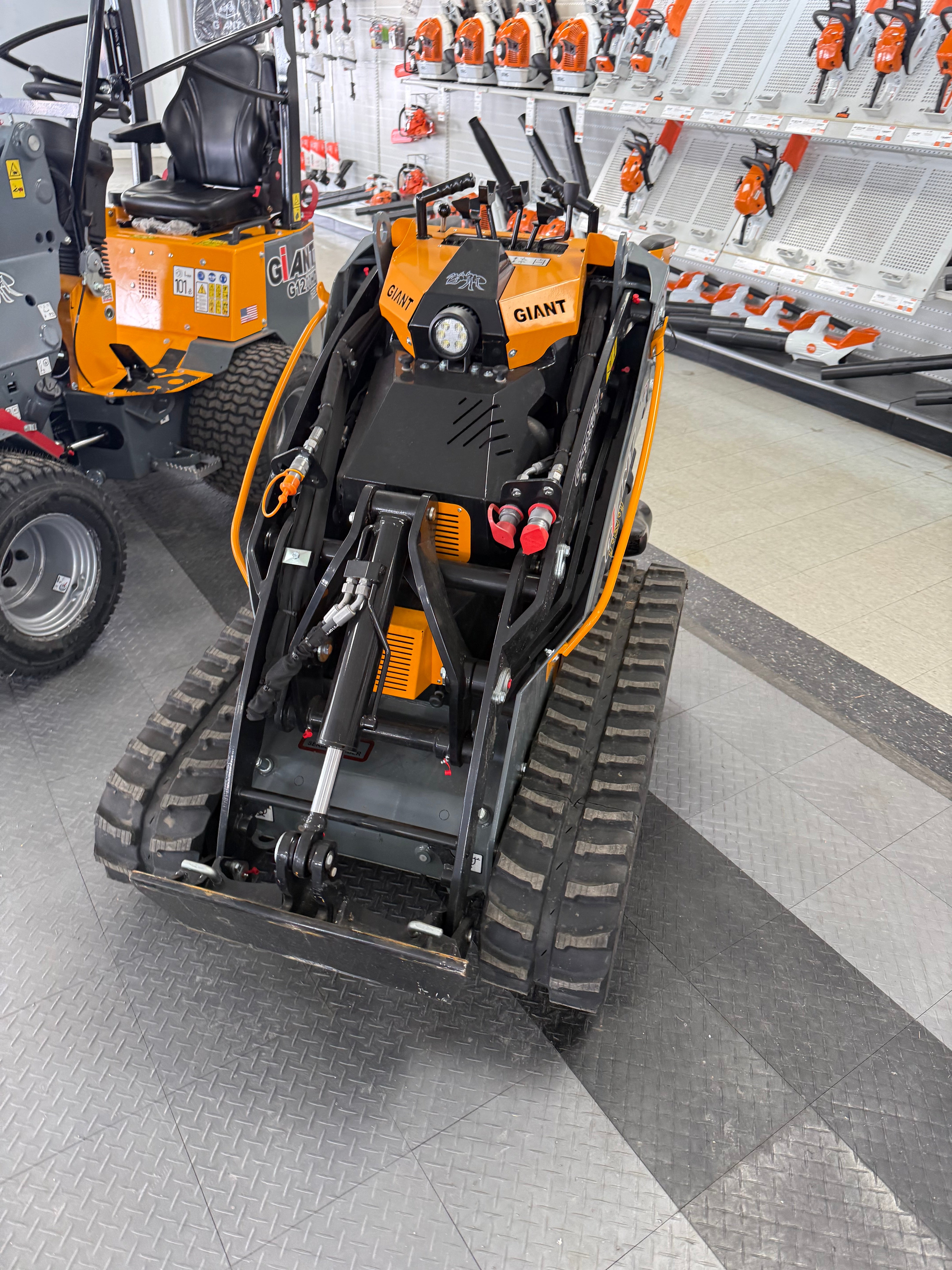Close-up of a forklift with tools and equipment on a gray floor.