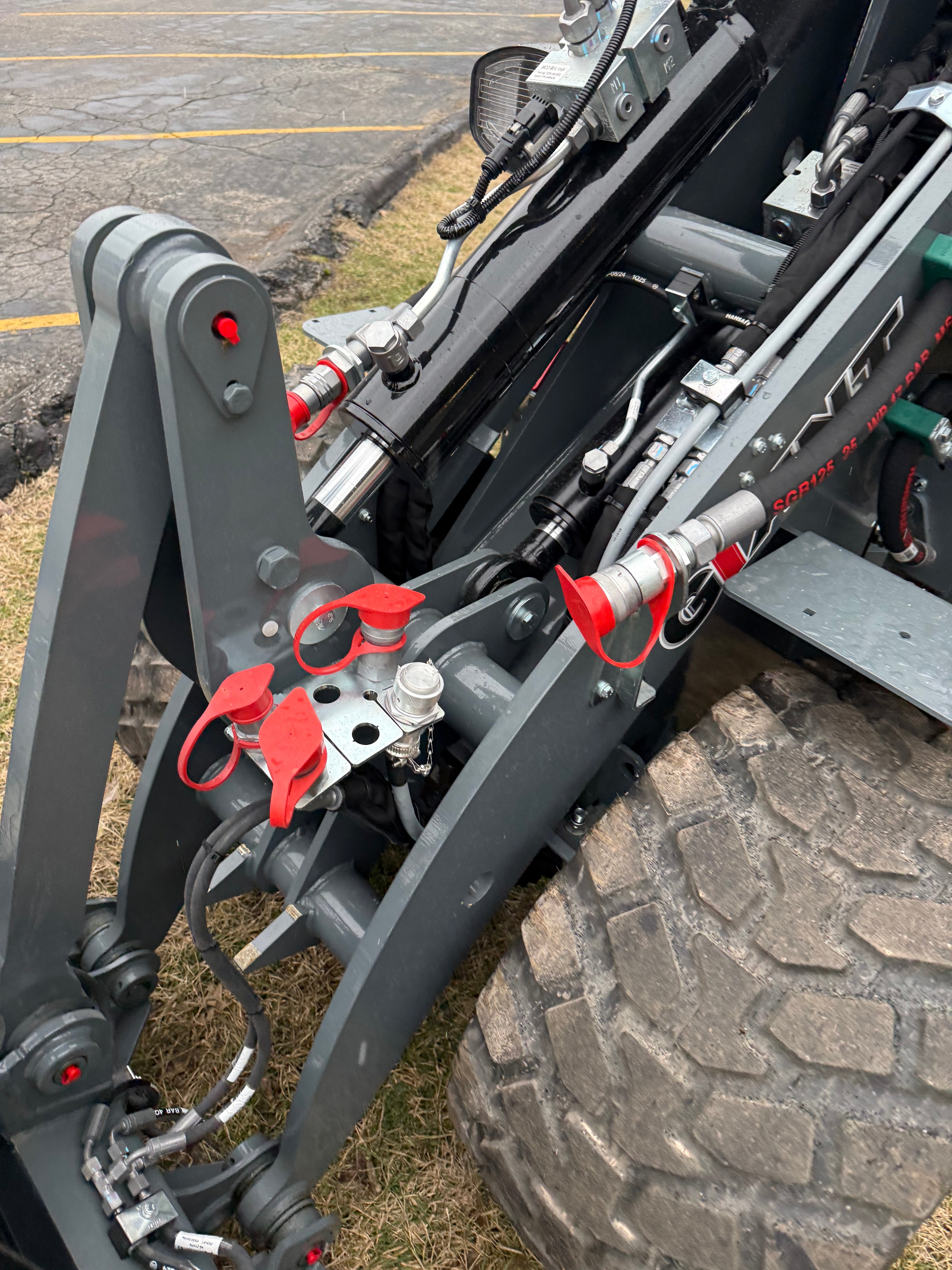 Close-up of a mechanical component with red clamps on a vehicle, likely a tow bar or similar equipment.