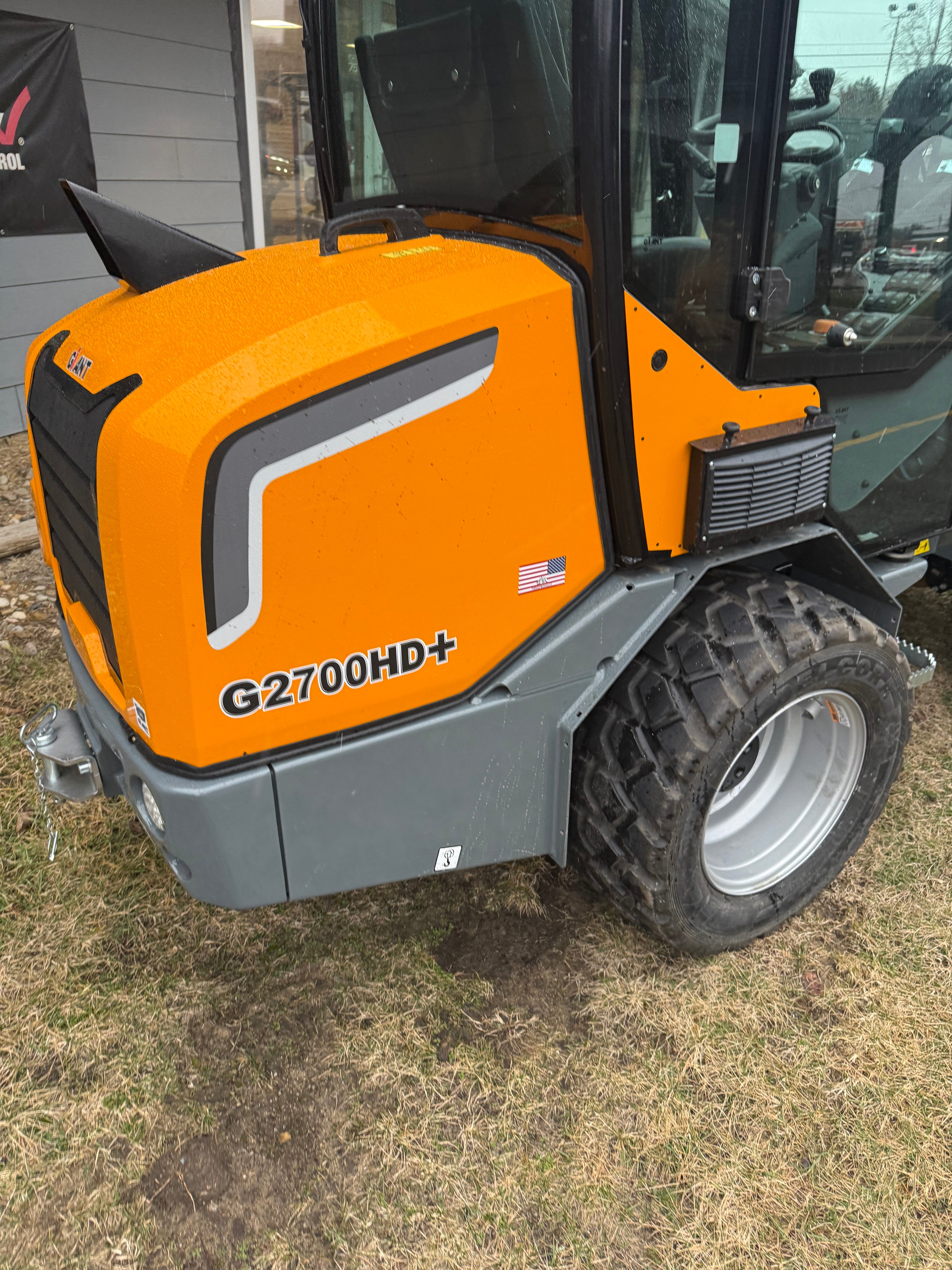 Yellow and gray Giantloader g700 HD+ skid steer on a grassy area