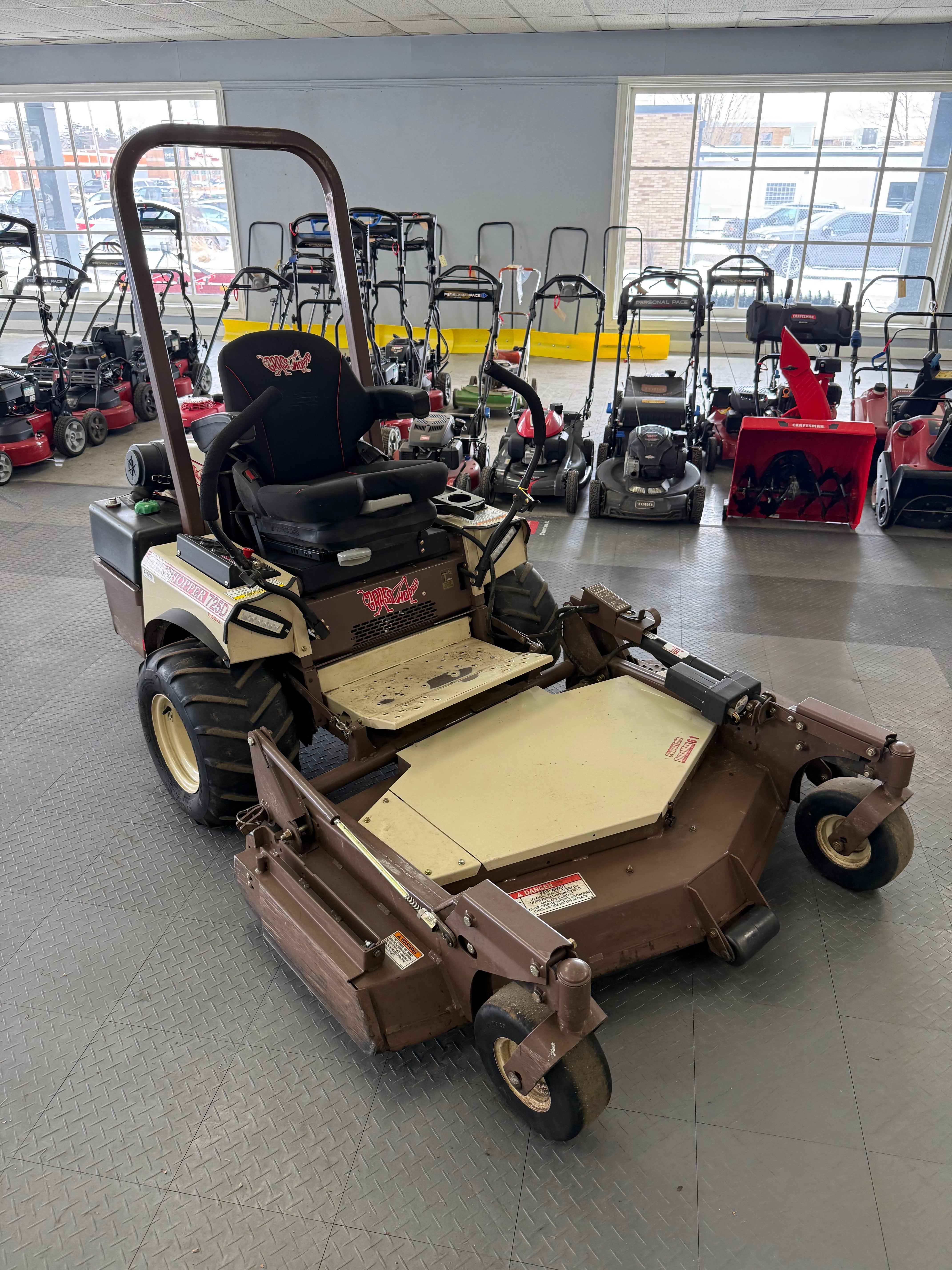 Mower on display in a showroom with other equipment.