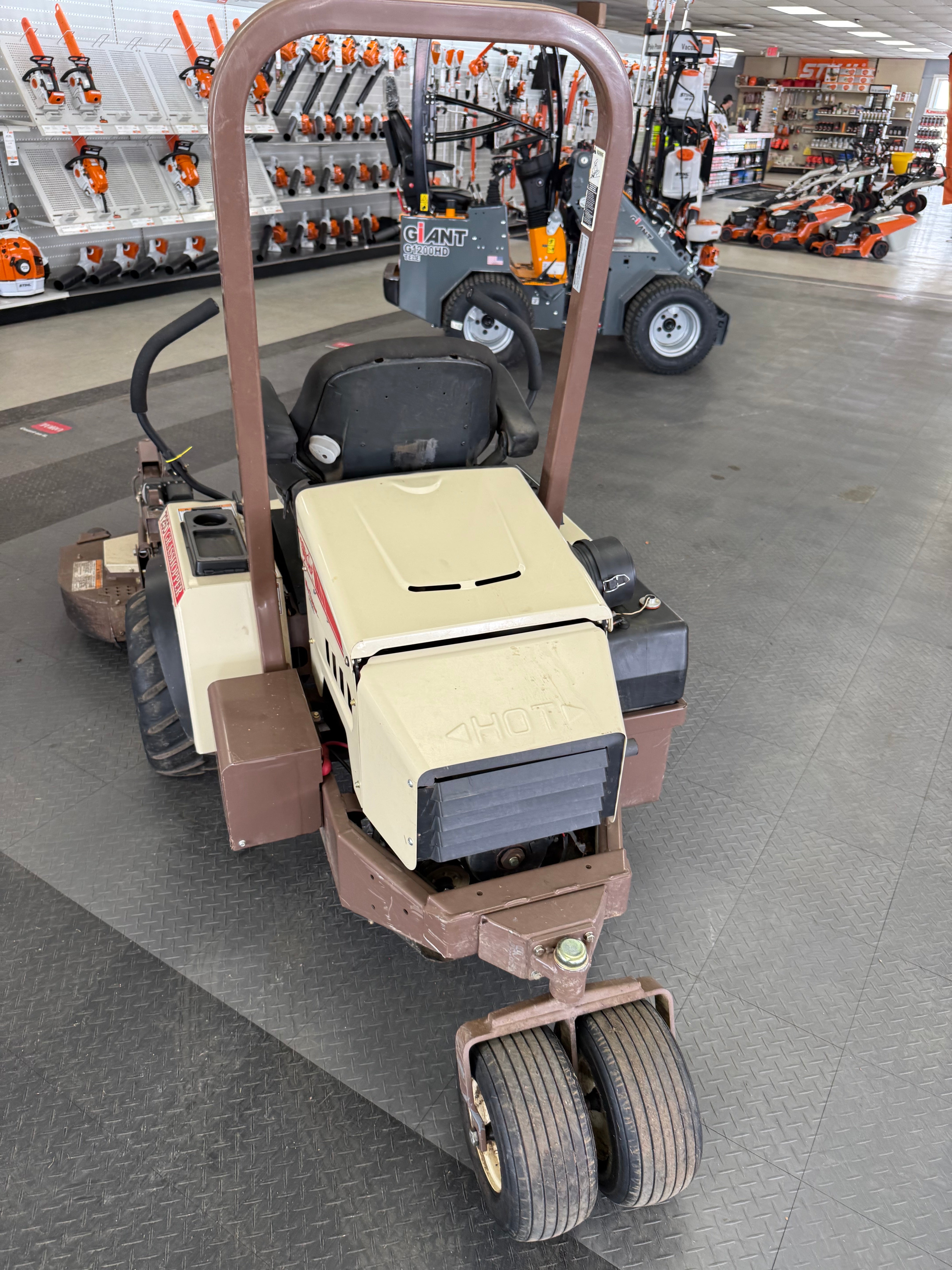 Small forklift in a warehouse setting with shelves and equipment in the background