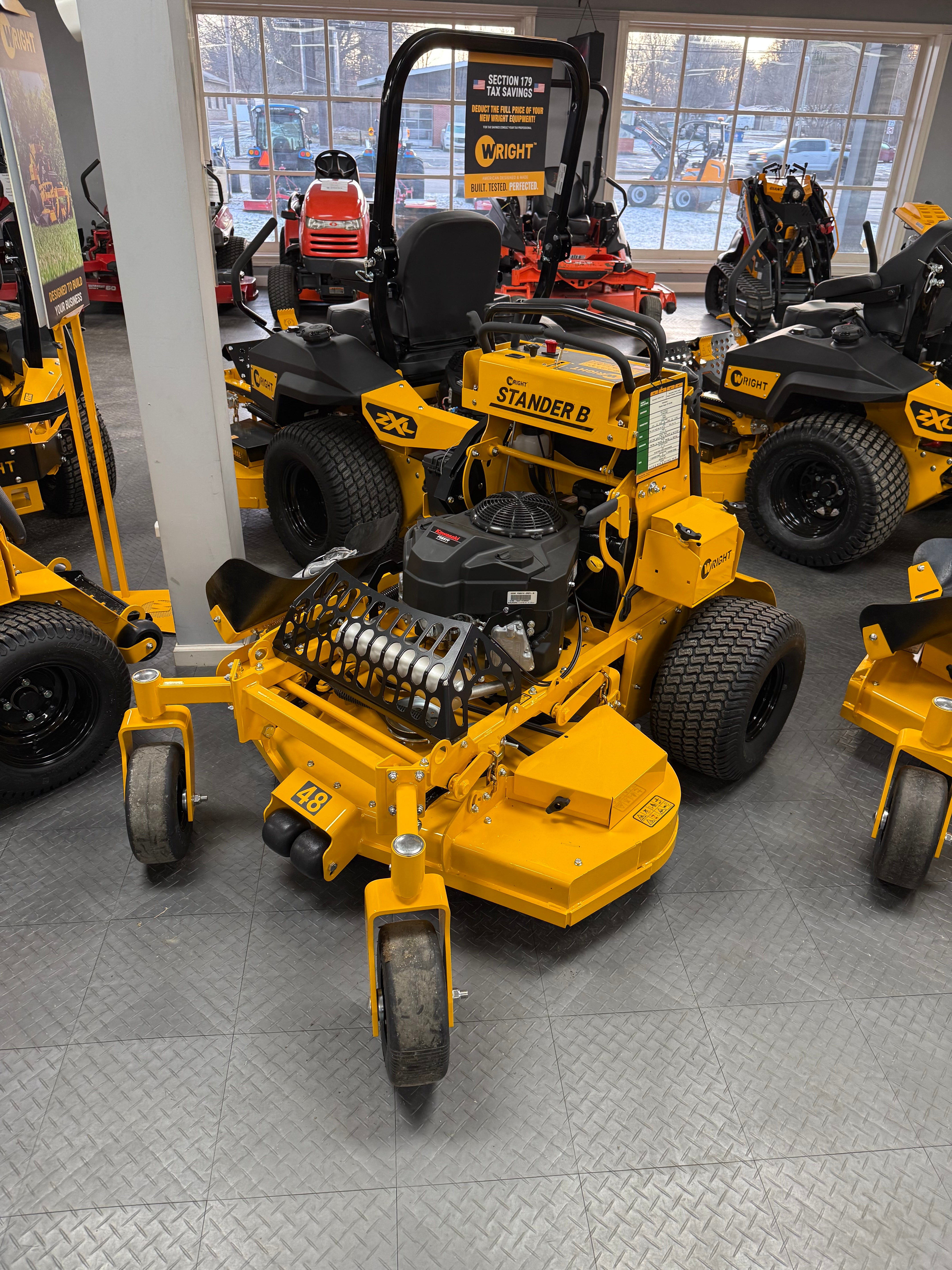 Yellow lawn mower on display in a showroom with large windows.