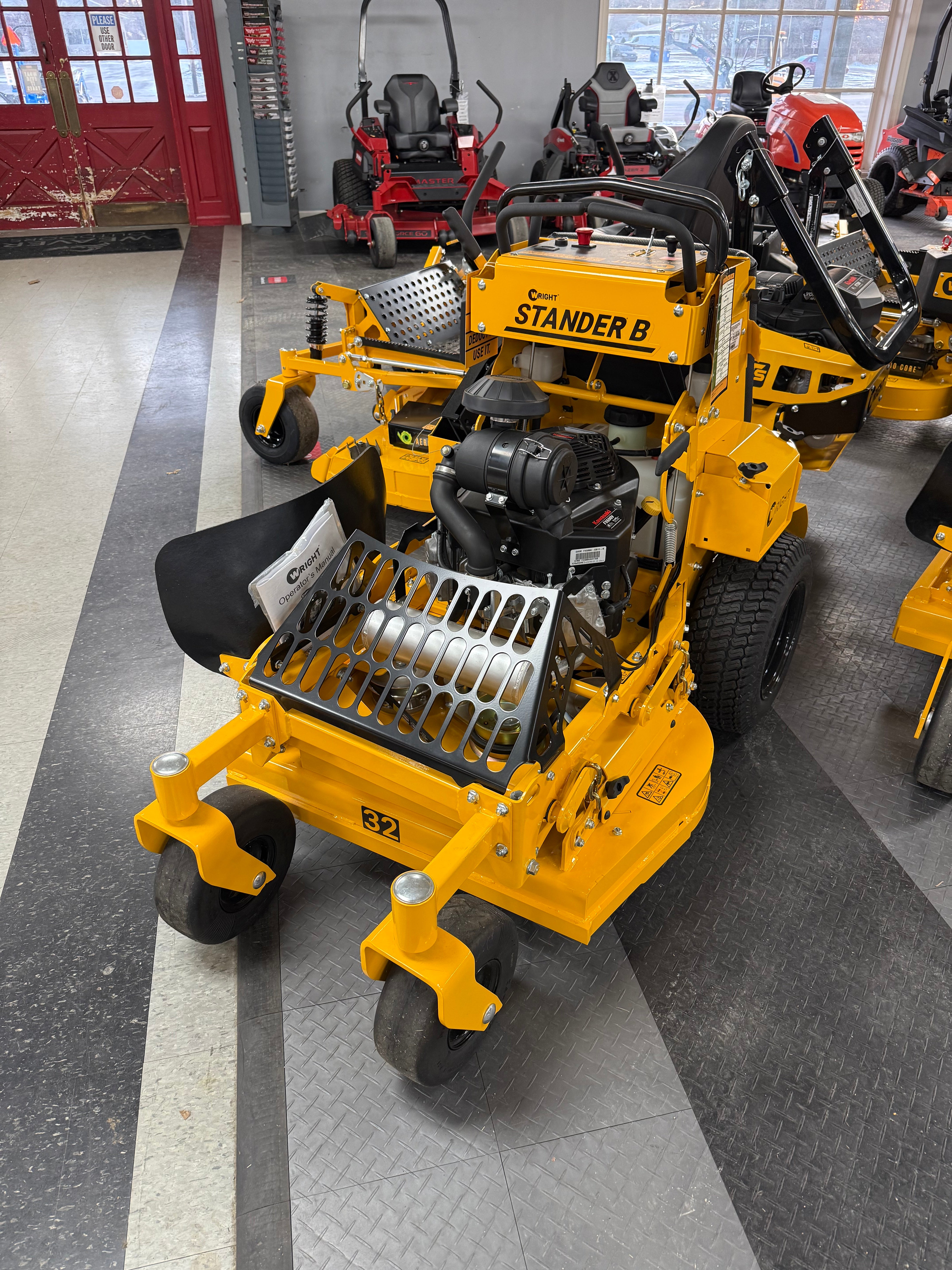Yellow stand-on mower on display in a showroom