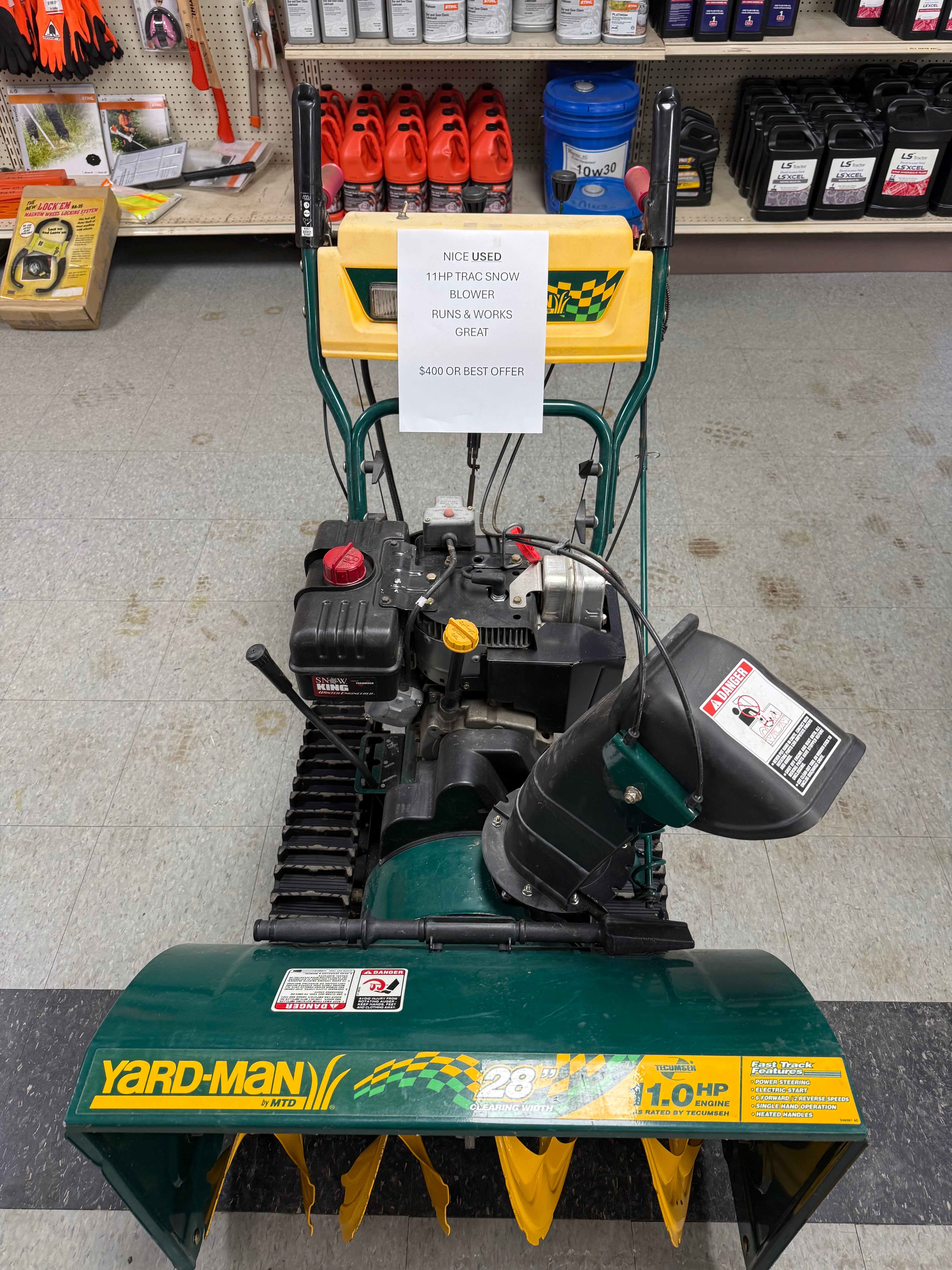 Yard-Man snow blower on a concrete floor with tools and equipment in the background